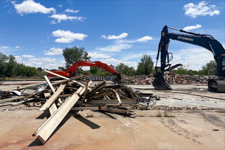 Two excavator preform a demolition of buildings on a CDOT property
