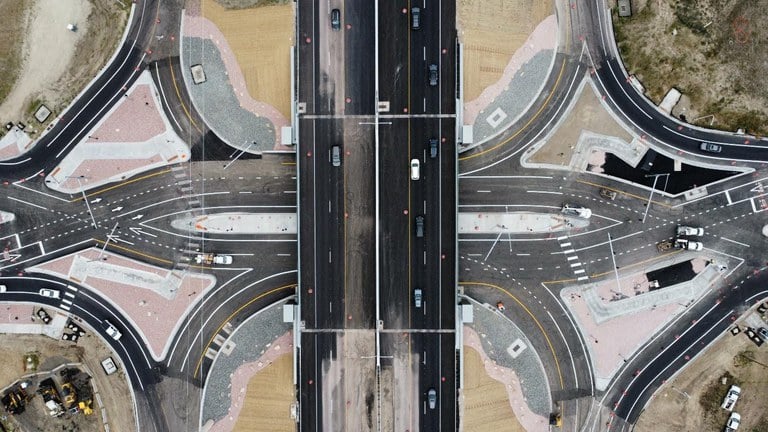 Overhead view of a diverging diamond interchange that have roads crisscrossing over one another in a diamond formation