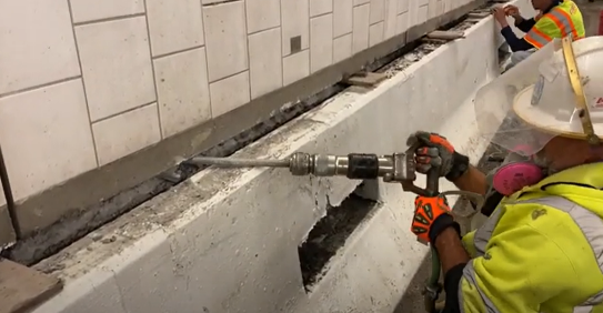 Crews using a jack hammer for wall repairs in the Eisenhower Johnson Memorial Tunnel detail image