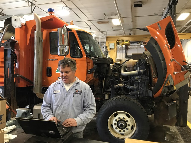 CDOT maintenance employee on computer with snowplow