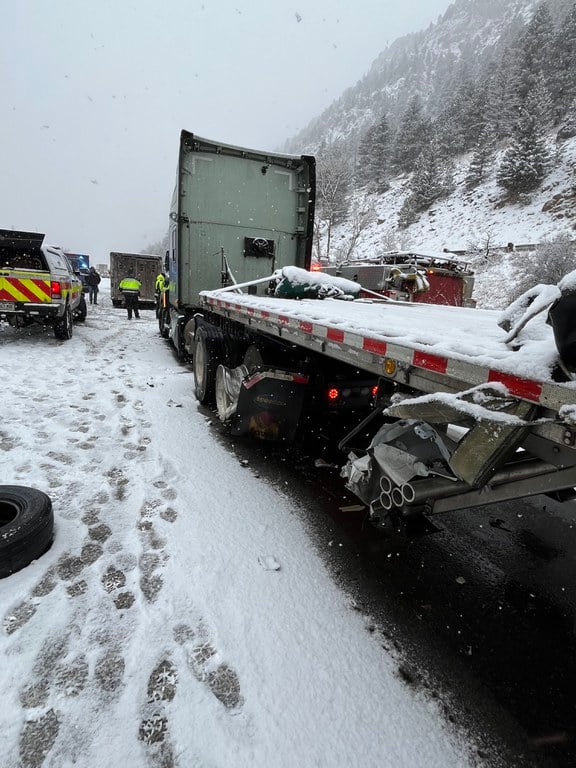 A tow truck parked on the side road with its bed covered in snow. Image captured from Monday, Feb. 16, I-70 westbound closure near Empire Junction/ Exit 232 and Georgetown/ Exit 228.