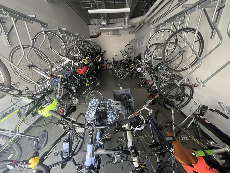 A photo showing a secure indoor bike parking room filled with bicycles