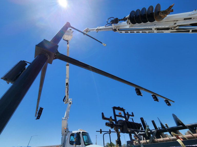 Crews with Sturgeon Electric attaching mast arms to the new signal poles at the CO 115 intersection at Broadway and Marilyn. 
