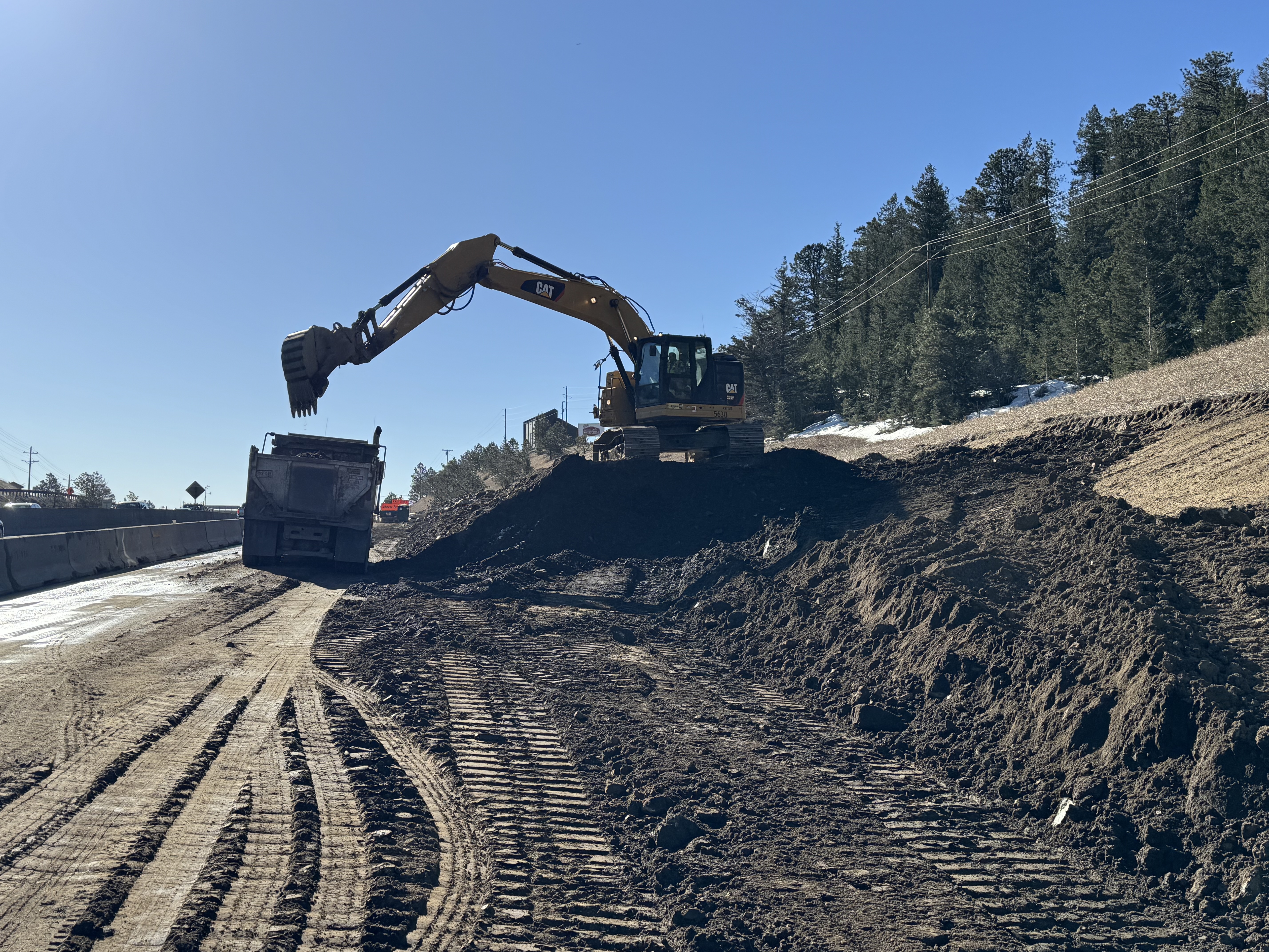 240411_Excavator loading dirt into truck_I-70 Floyd Hill.JPG detail image
