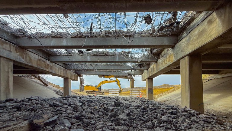 Construction work under the Valley Road Bridge with the blue sky peaking through the gaps in the bridge.