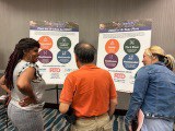 Three people conversing while facing the Colorado Boulevard BRT boards