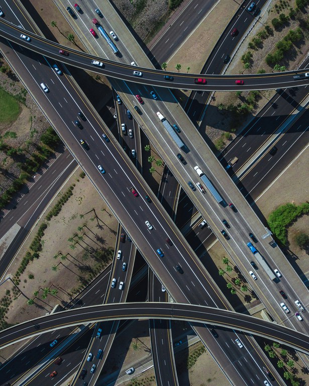 Large highway interchange with several cars and trucks on the road.