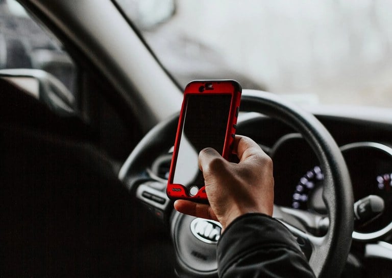 Person using cell phone while driving.